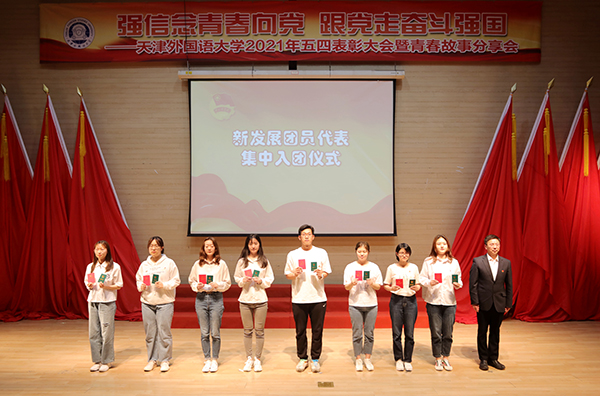 校党委副书记胡志刚为新团员代表颁发团员证和团章